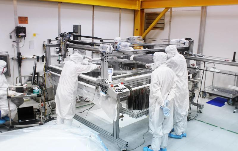 Members of SLAC’s LZ team with loom used to weave high-voltage grids.