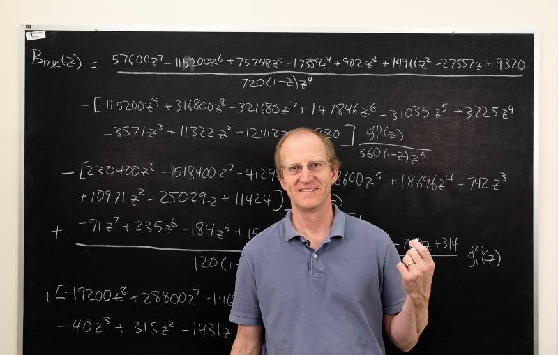 A man standing in front of a chalkboard.