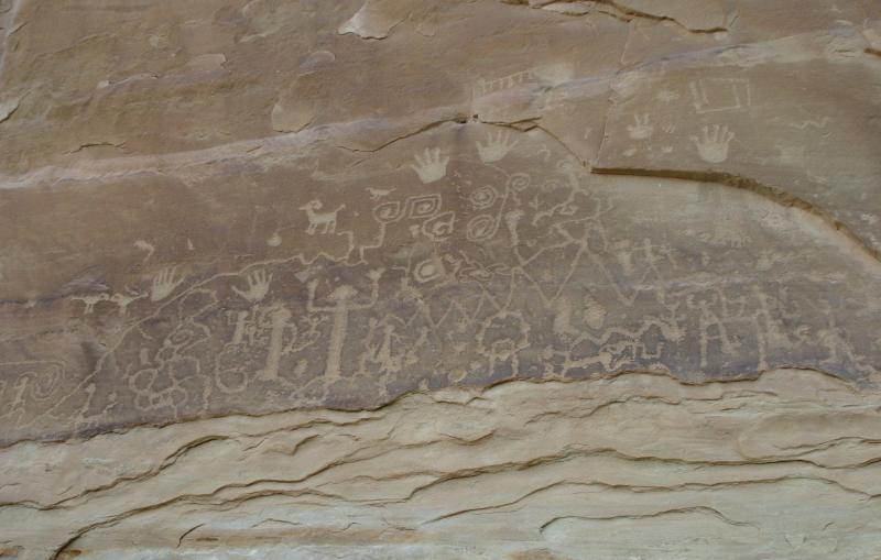 Rock art featuring human and animal forms and handprints