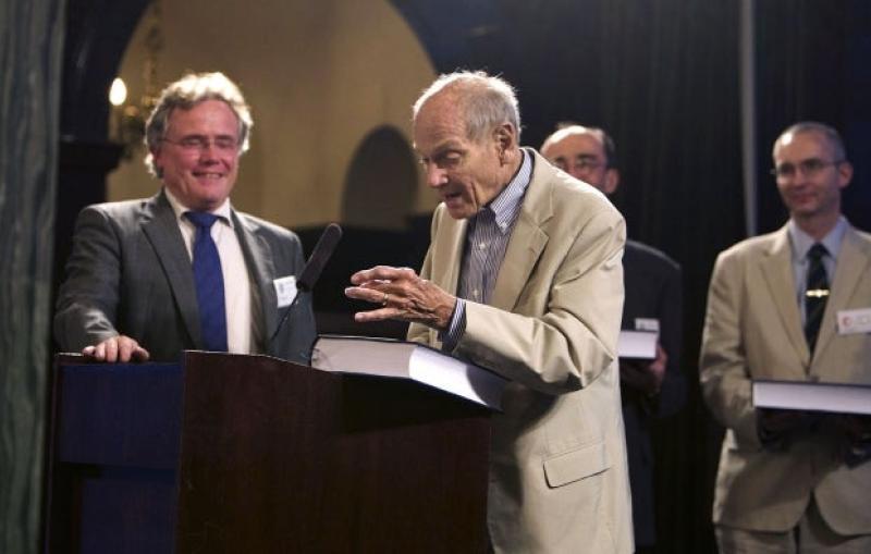 Man at podium with a big book