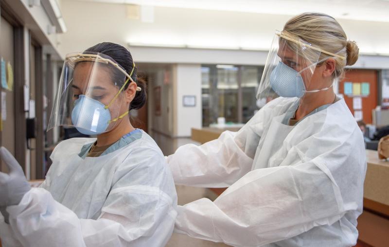 Medical workers donning personal protective equipment