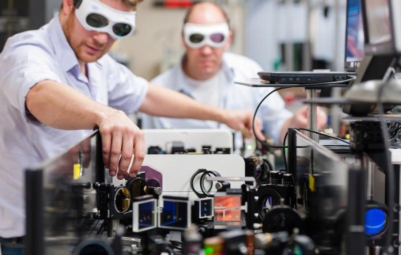 Photo - Two laser specialists wearing goggles, adjust...