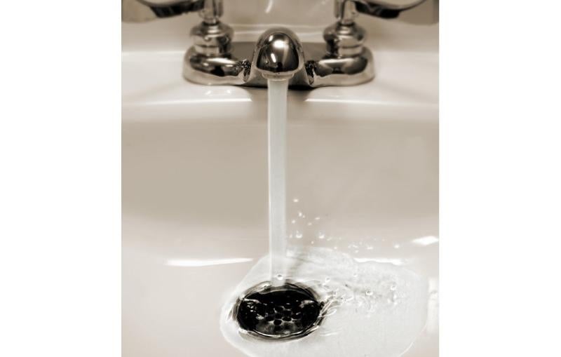 Image of a sink with water flowing down the drain.