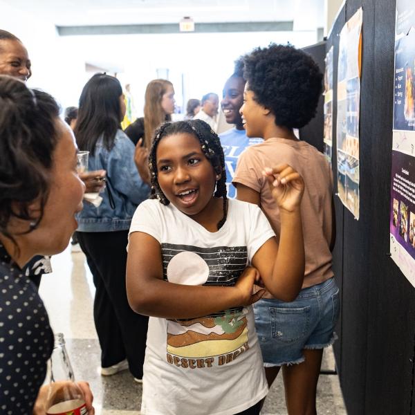 A student presents her work on a poster.