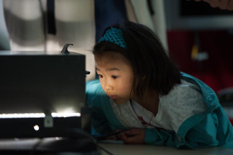 Photo - Young girl looking into bubble chamber.