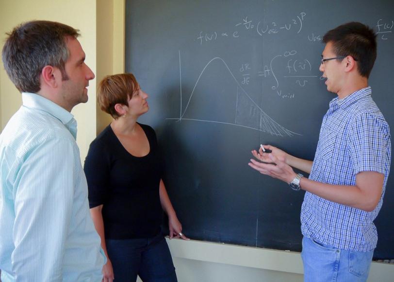 KIPAC theorists (l to r) Louis Strigari, Risa Wechsler and Yao-Yuan Mao discussing dark matter velocity distributions. (Credit: Luis Fernandez.)