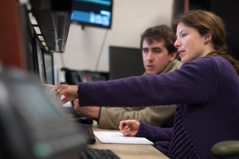 Photo - Silke Nelson, right, engineering physicist for the XPP instrument at LCLS, showing intern Tyler Couto, left, how to operate the XPP controls system. (Matt Beardsley)