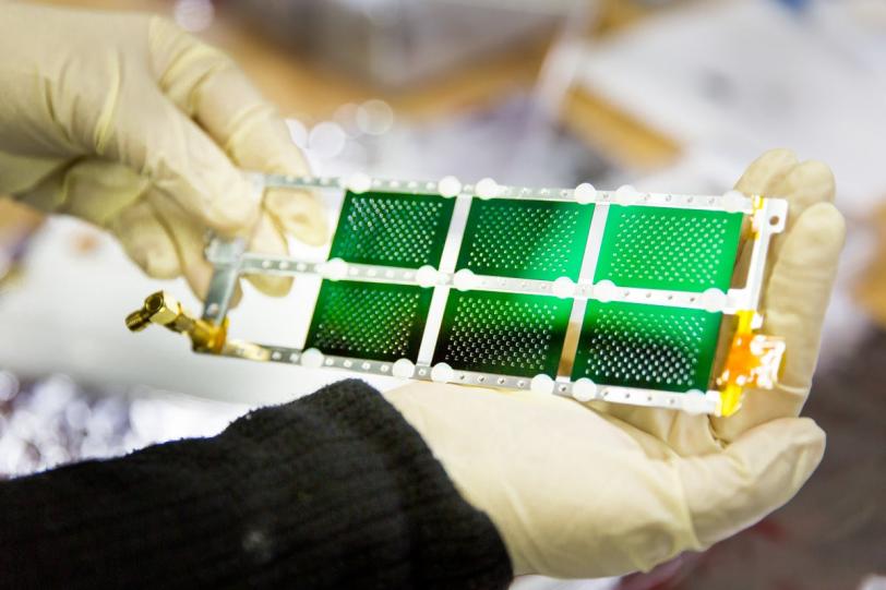 Photo - Despina Milathianaki, a staff scientist at SLAC's LCLS, holds a series of titanium alloy samples prepared for an experiment. The experiment was designed to study the laser-shocked state of the materials. (Fabricio Sousa/SLAC)