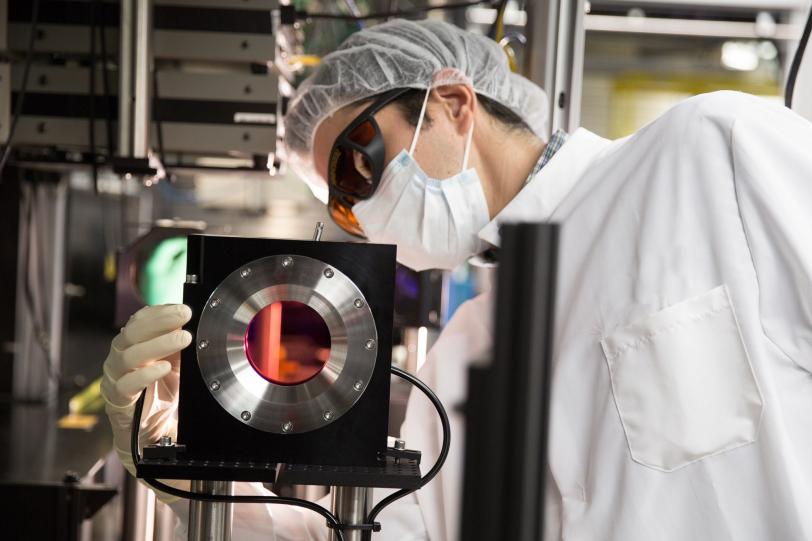 Image - Eduardo Granados inspects a large titanium sapphire crystal, the operative component in a newly upgraded high-power laser system that is designed to work in conjunction with a unique X-ray laser at SLAC.