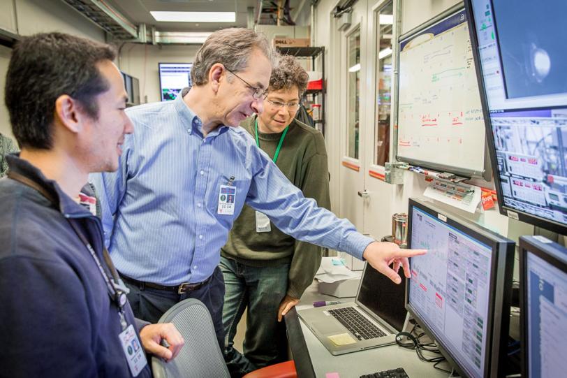 Photo - Nicholas Sauter, middle, points to a monitor during an experiment this month at SLAC's Linac Coherent Light Source X-ray laser.