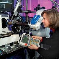 A woman operating a handheld computer and machinery