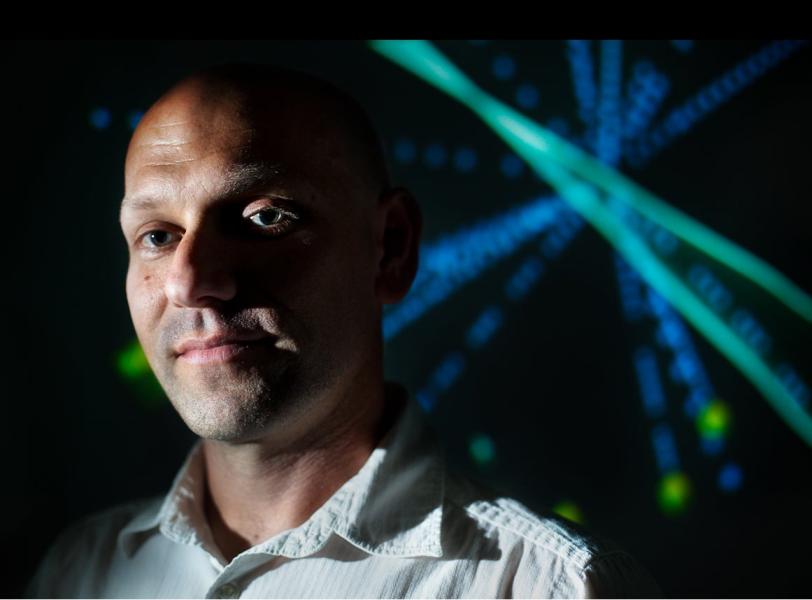 Matt Bellis with the Particle Physics Windchime in the background (Photo by Brad Plummer.)