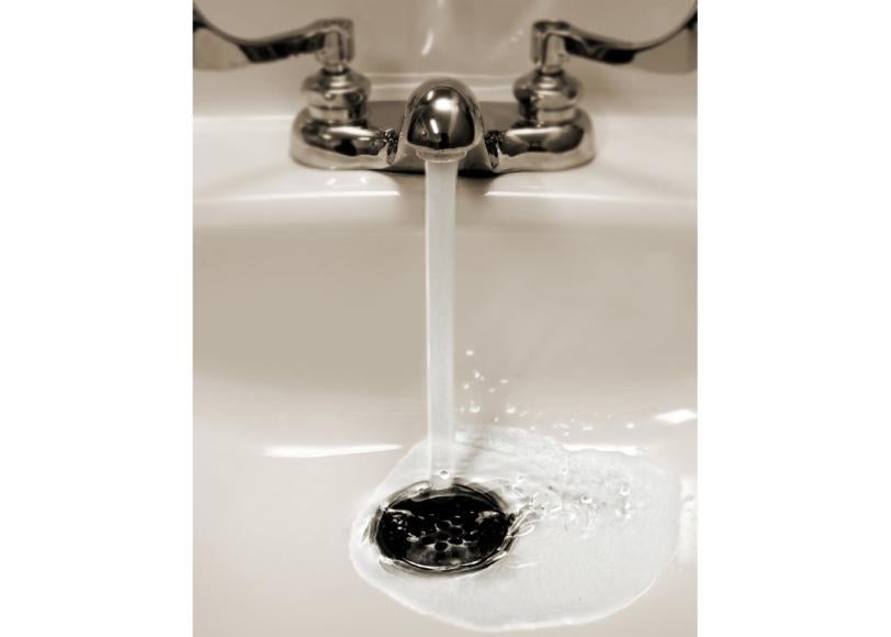 Image of a sink with water flowing down the drain.