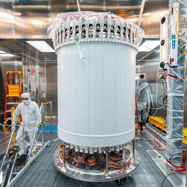 A tall white cylinder stands in a clean room space.