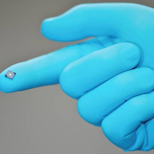 Photo - Diamond zone plate on the tip of a researcher's finger. The diamond zone plate fits on the tip of the researcher's finger